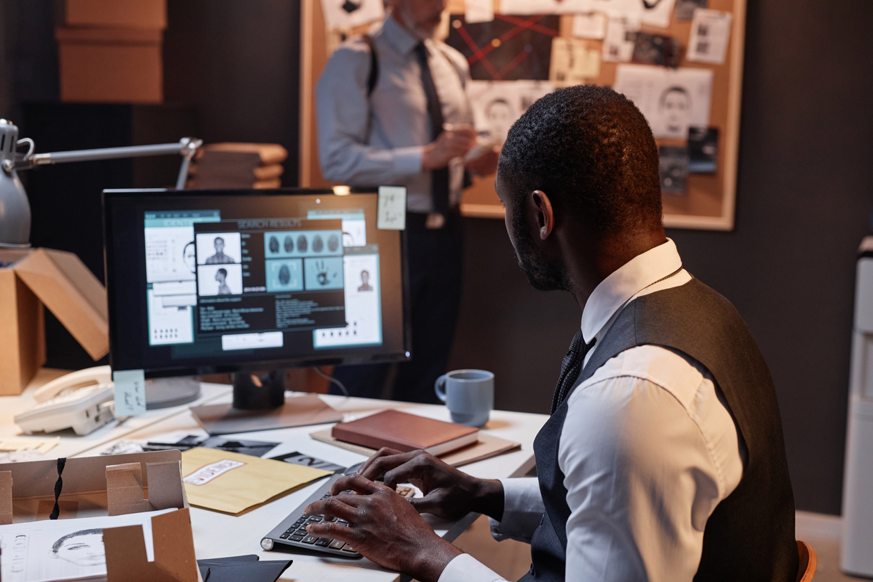 A detective reviews a case file on his computer.