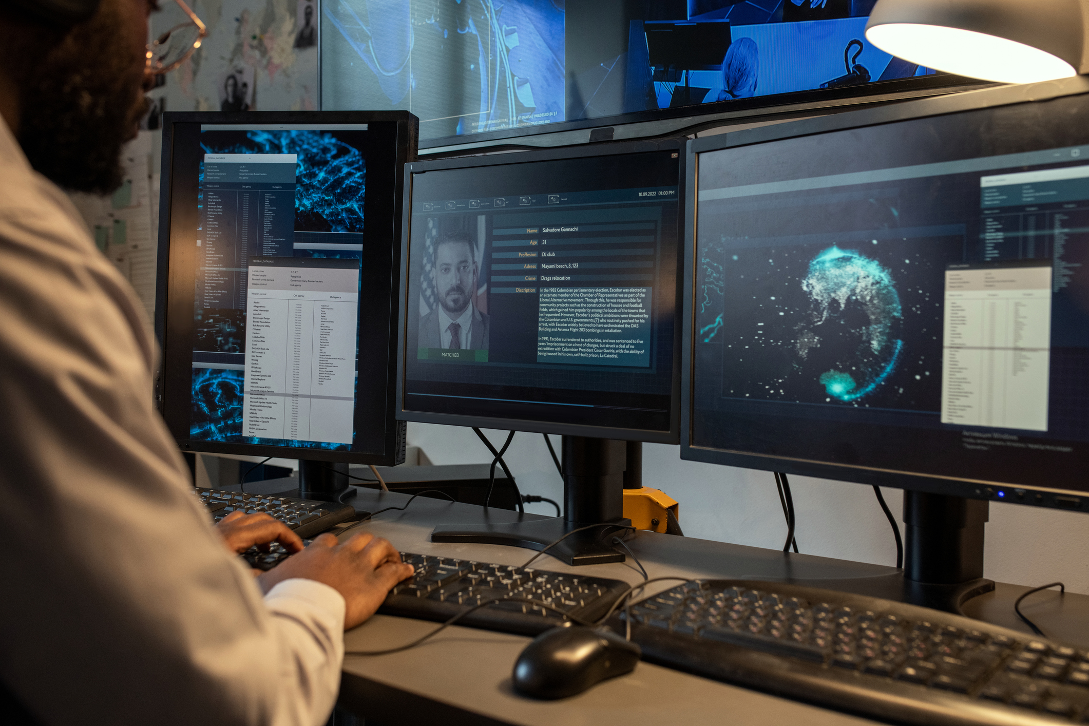 A crime analyst works at a desk. 