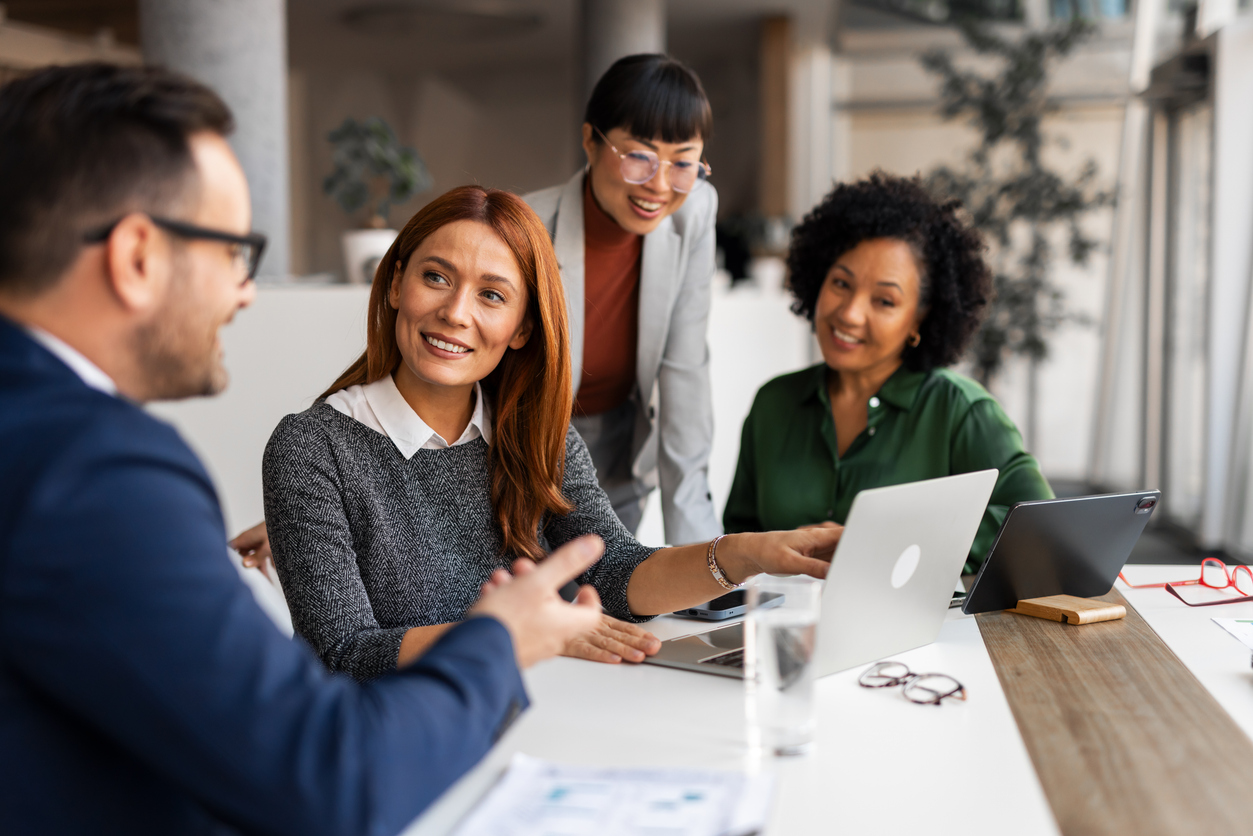 A marketing team meets around a conference table.