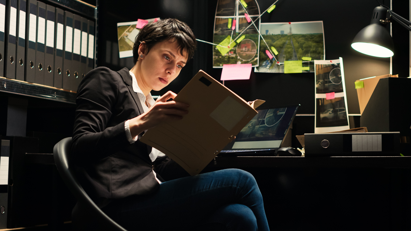 A criminalist studies a case file in her office.