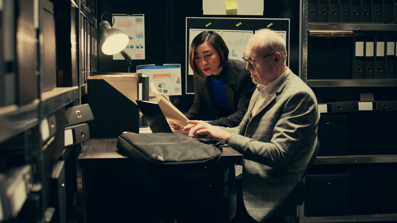 Two criminal justice professionals look at files in a room. 