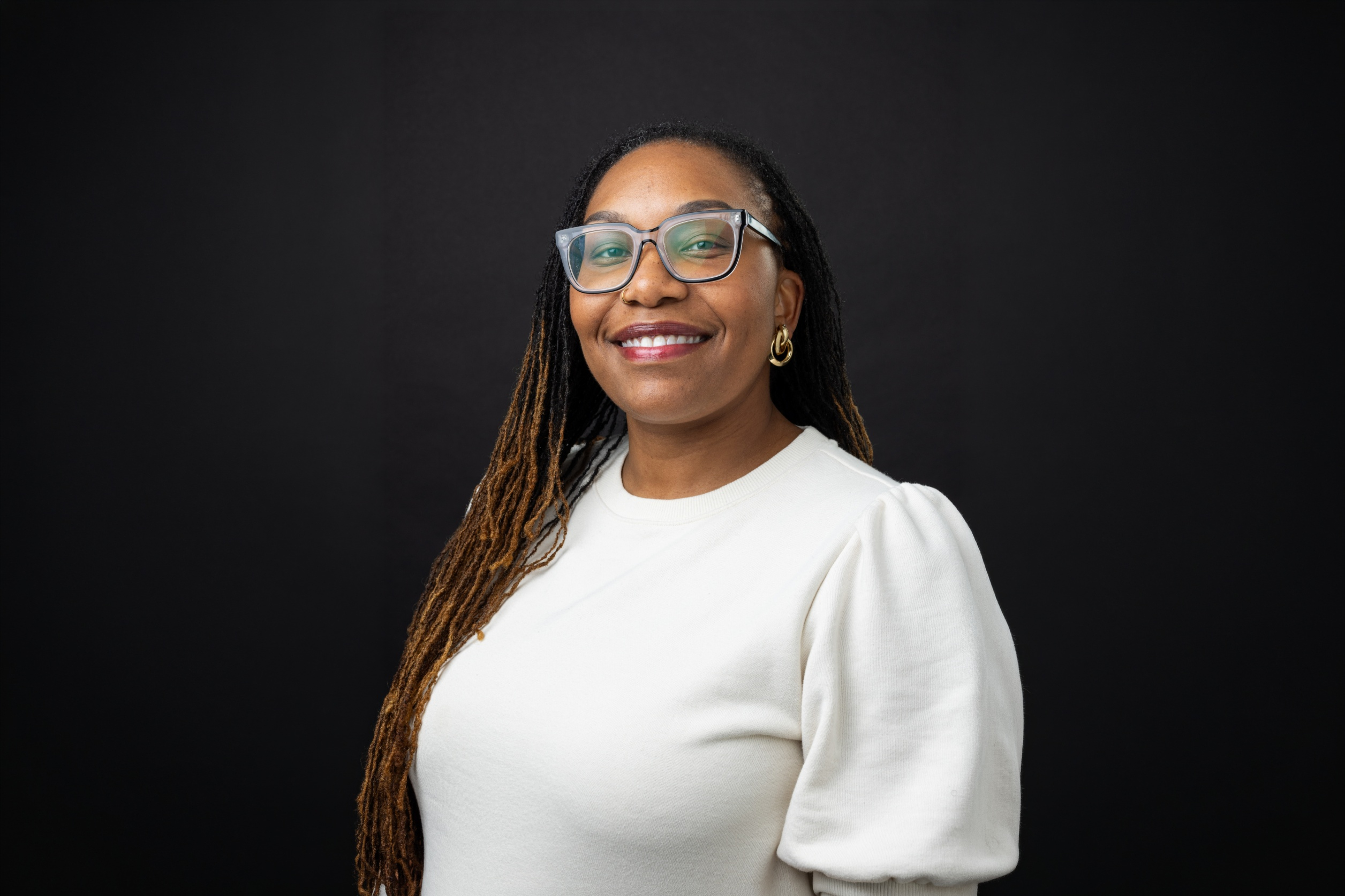 Headshot of Dr. Tempestt Adams in front of a black background.